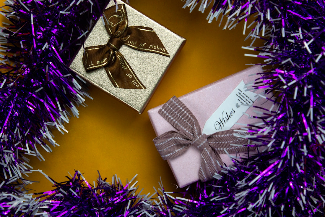 a gift wrapped in a purple and silver ribbon