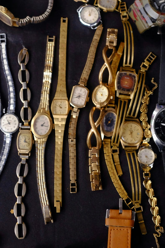a table topped with lots of different types of watches