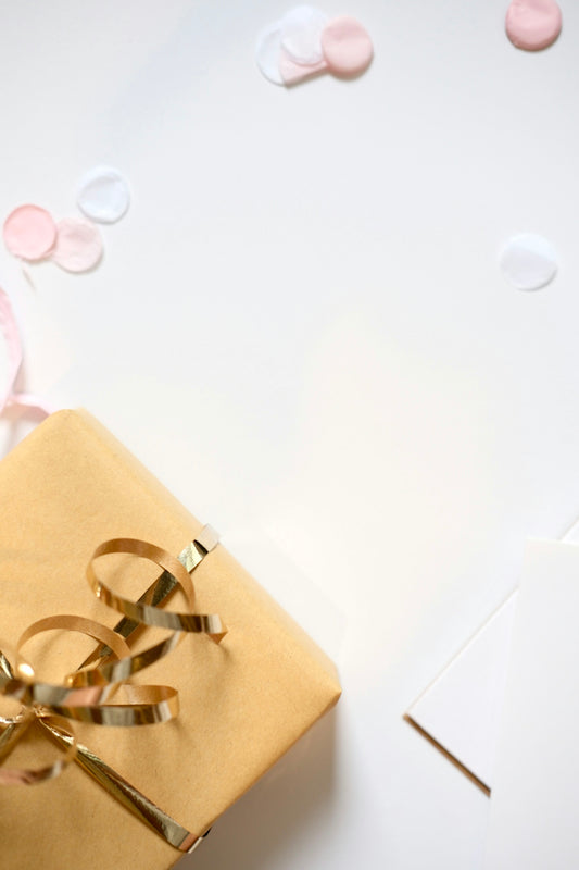 Gift wrapped in gold ribbon with confetti and confetti